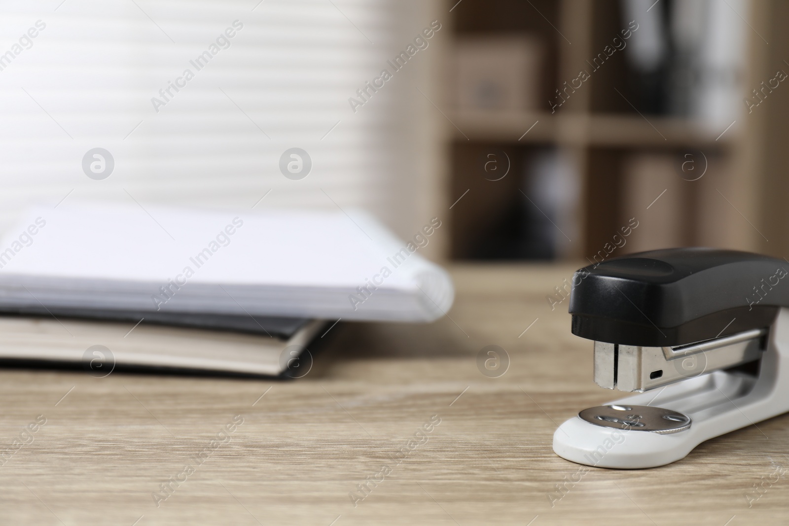 Photo of One stapler on wooden table indoors, closeup. Space for text