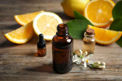 Photo of Bottles of citrus essential oil on wooden table