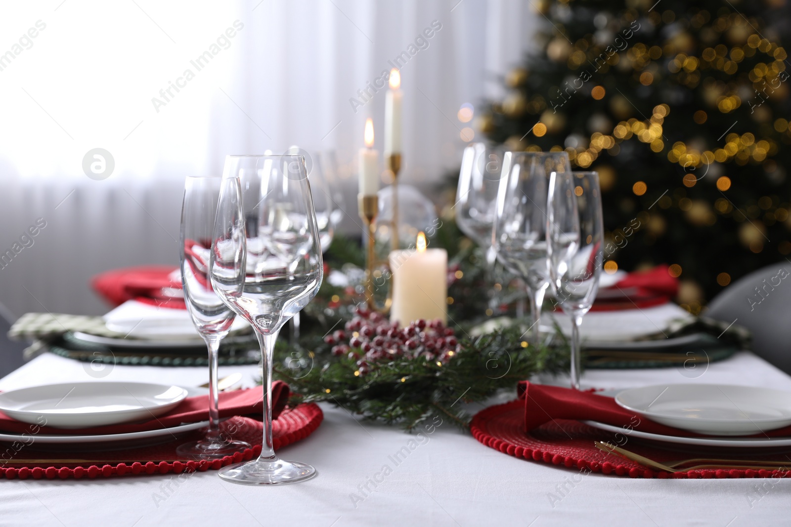 Photo of Christmas table setting with festive decor and dishware indoors