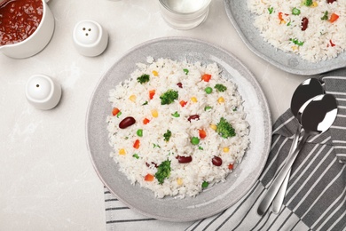 Photo of Boiled rice with vegetables served on table, flat lay