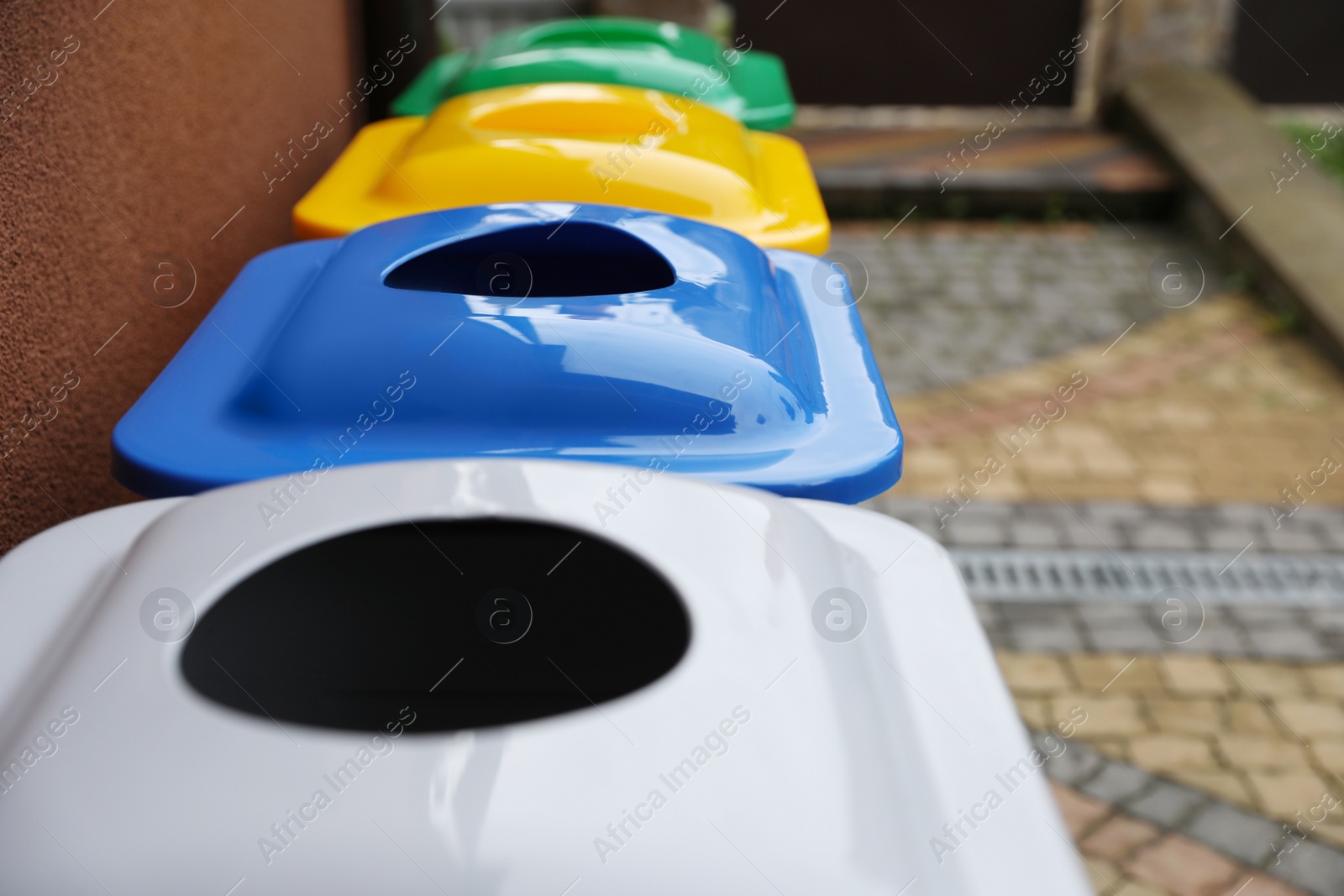 Photo of Many color recycling bins outdoors, closeup. Space for text