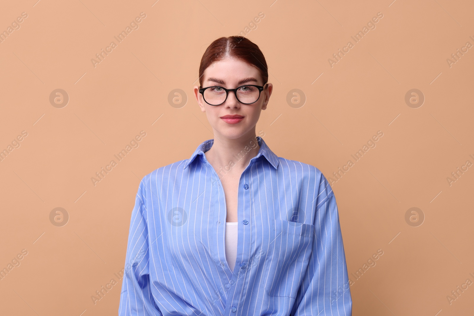 Photo of Portrait of beautiful woman in glasses on beige background