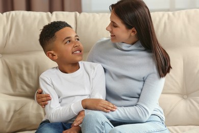 Photo of Mother with her African American son on sofa. International family