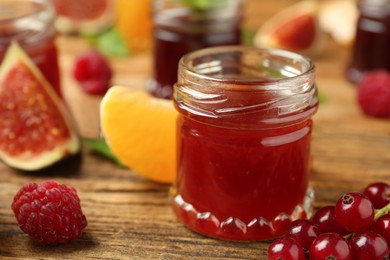 Photo of Jar of jam and ingredients on wooden table, closeup