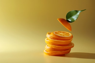 Photo of Slices of juicy orange and leaf on beige background. Space for text