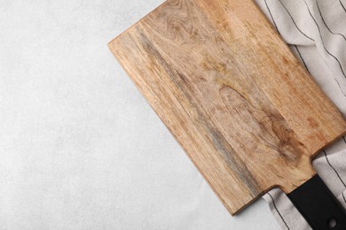 Photo of One wooden cutting board on light grey table, top view with space for text. Cooking utensil