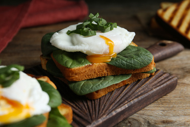 Delicious poached egg sandwich served on wooden board