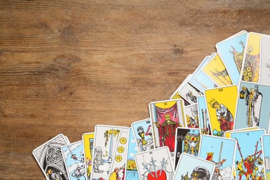 Tarot cards on wooden table, top view. Space for text