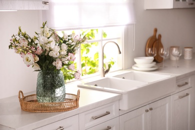 Photo of Bouquet of beautiful flowers on countertop in kitchen, space for text. Interior design