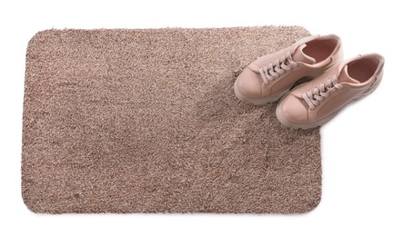 Photo of Stylish door mat with shoes on white background, top view