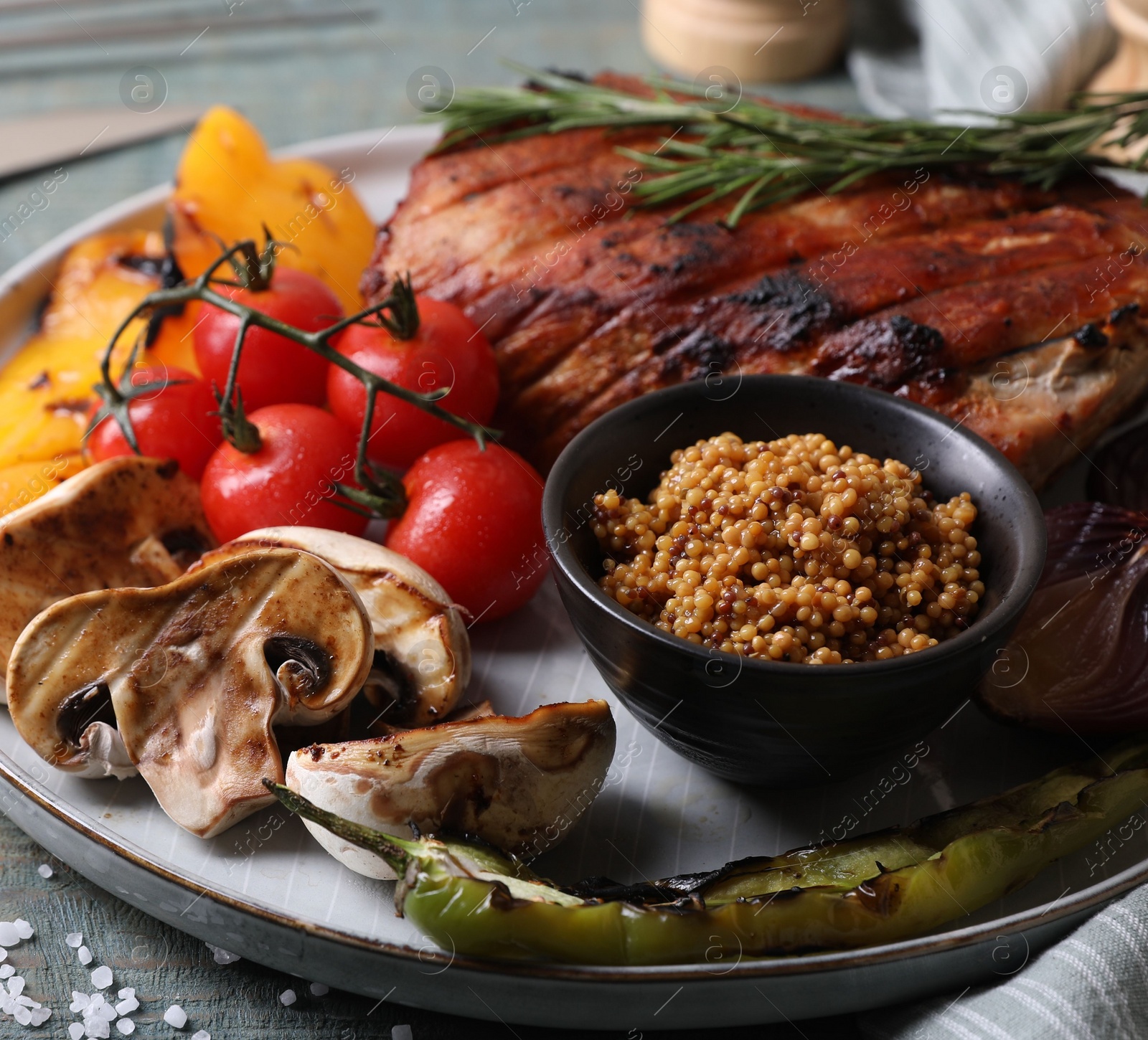 Photo of Delicious grilled meat and vegetables served on wooden table, closeup