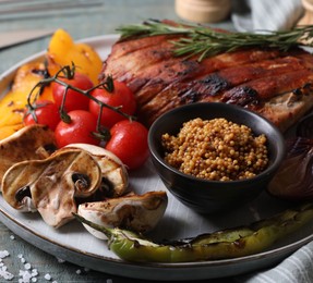 Photo of Delicious grilled meat and vegetables served on wooden table, closeup