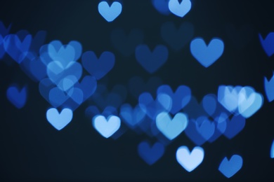 Photo of Blurred view of beautiful heart shaped lights on dark background