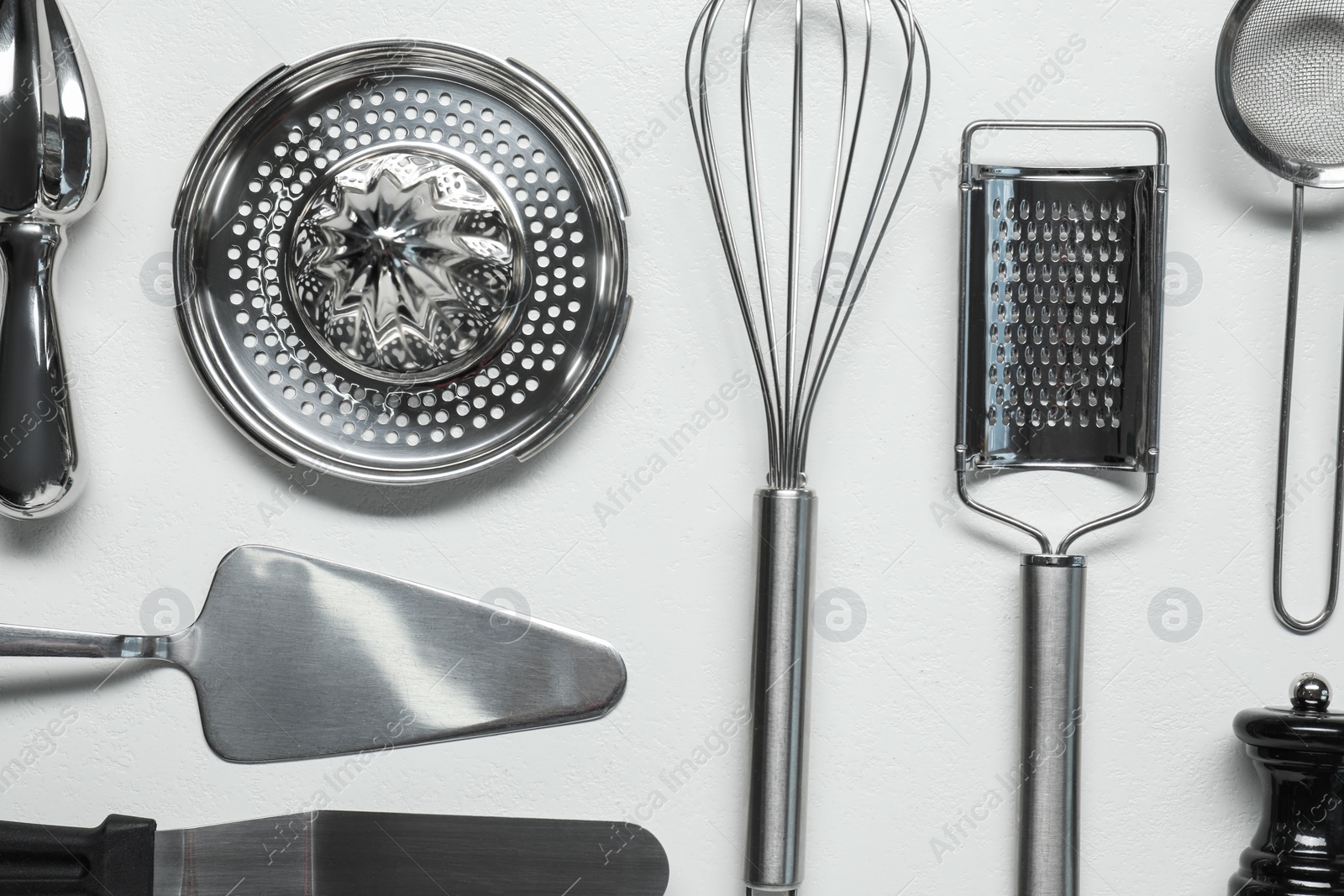 Photo of Set of different kitchen utensils on white table, flat lay