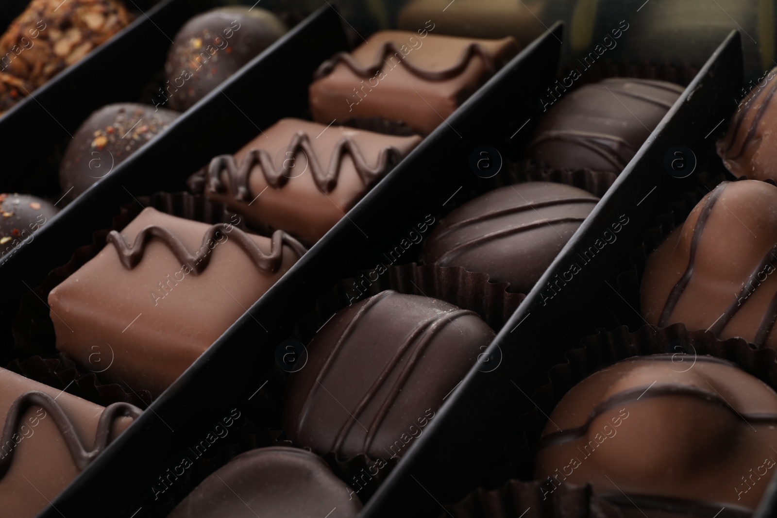 Photo of Many different chocolate candies in box, closeup