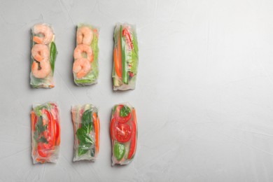 Photo of Spring rolls wrapped in rice paper on light table, flat lay. Space for text