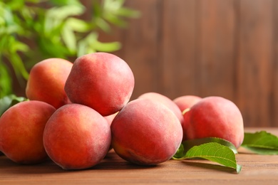 Fresh sweet ripe peaches on wooden table