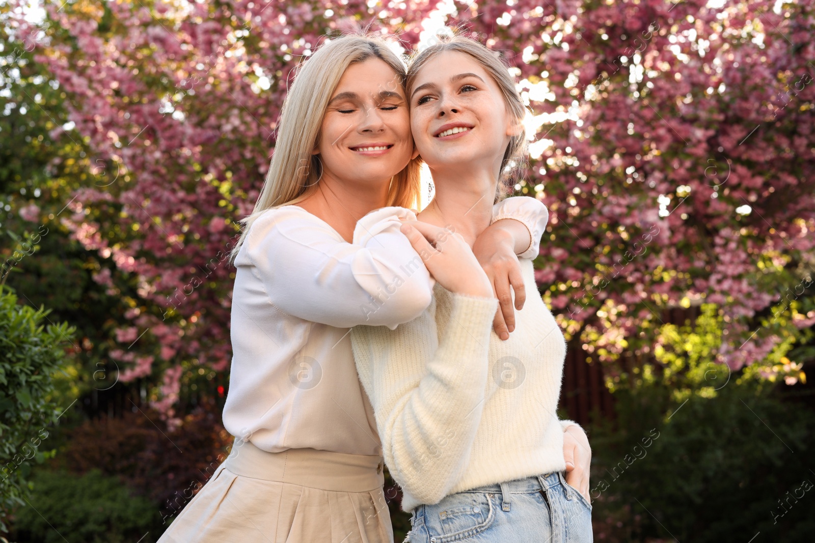 Photo of Happy mother with her daughter spending time together in park on sunny day