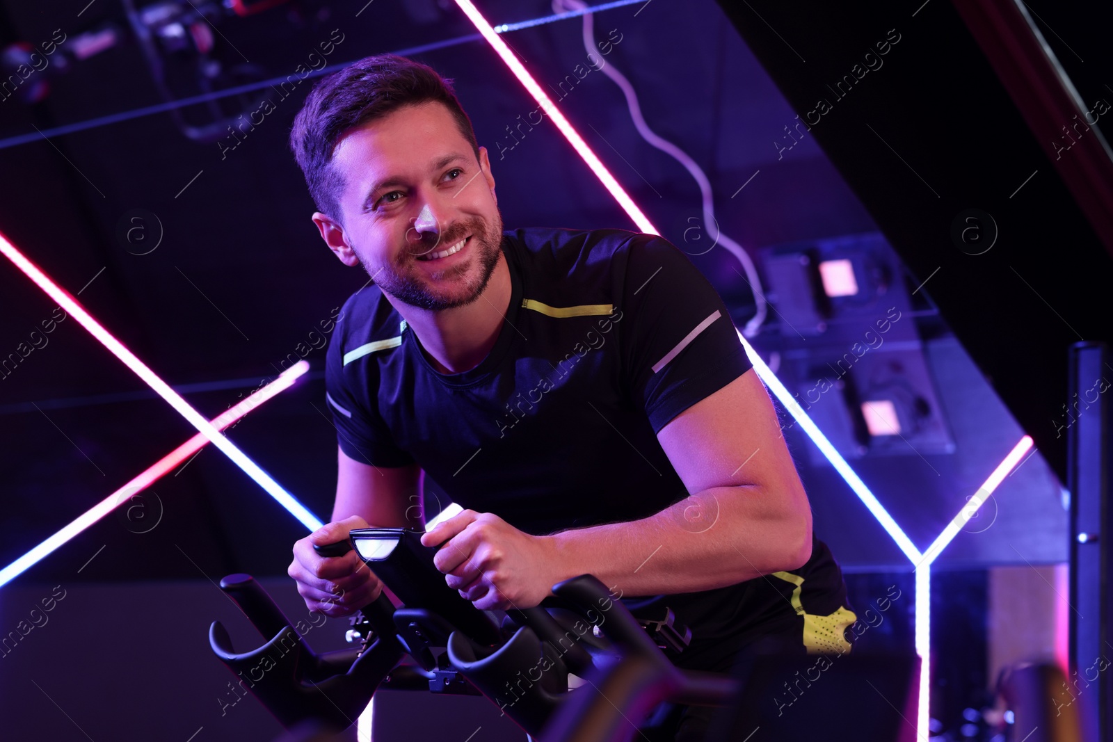 Photo of Man training on exercise bike in fitness club