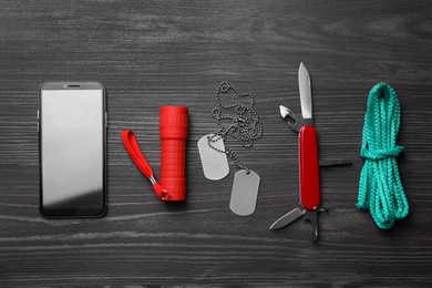 Photo of Flat lay composition with compact portable multitool and accessories on black wooden table