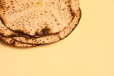 Photo of Tasty matzos on beige background, space for text. Passover (Pesach) celebration