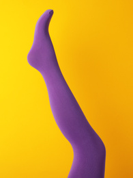 Photo of Leg mannequin in purple tights on yellow background