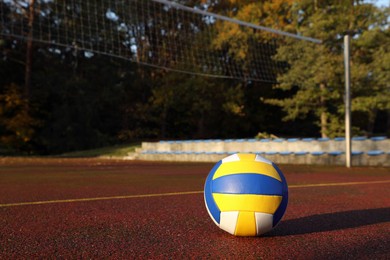 Photo of View of colorful ball on volleyball court outdoors