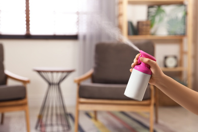 Photo of Woman spraying air freshener at home, closeup