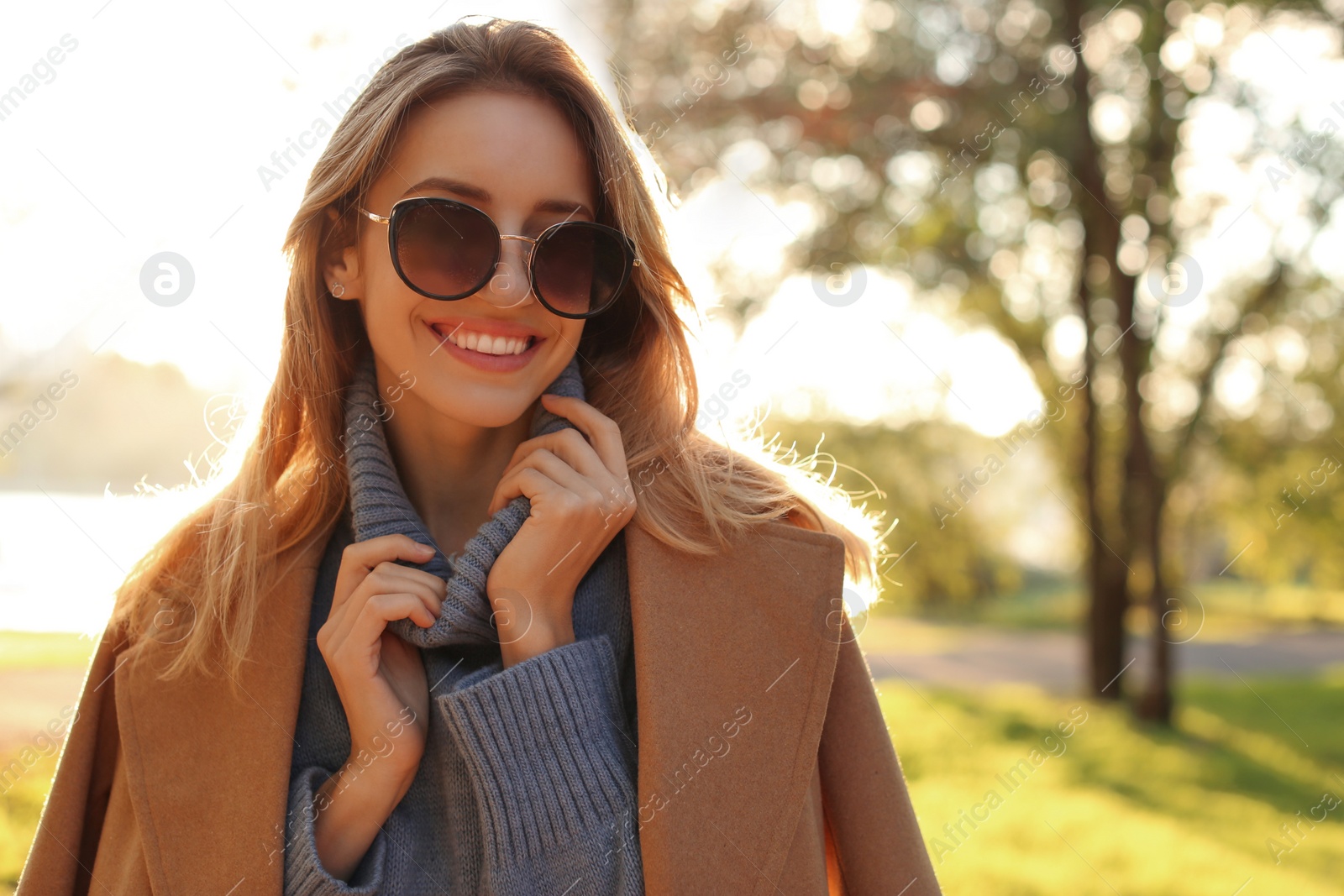 Photo of Beautiful young woman wearing stylish clothes in autumn park