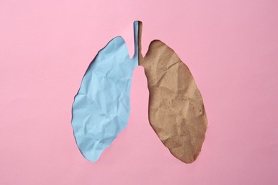 Photo of Pink paper with cutout in shape of human lungs, top view. Influence of unhealthy lifestyle