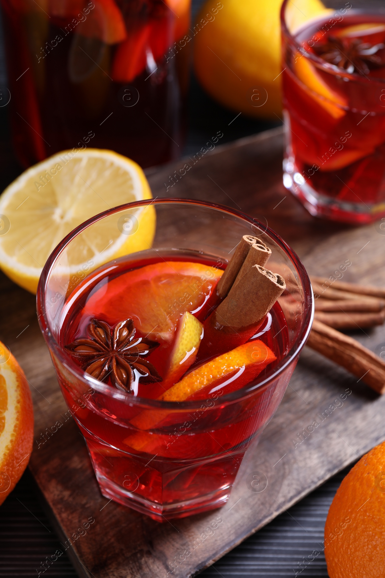 Photo of Glass of aromatic punch drink and ingredients on table