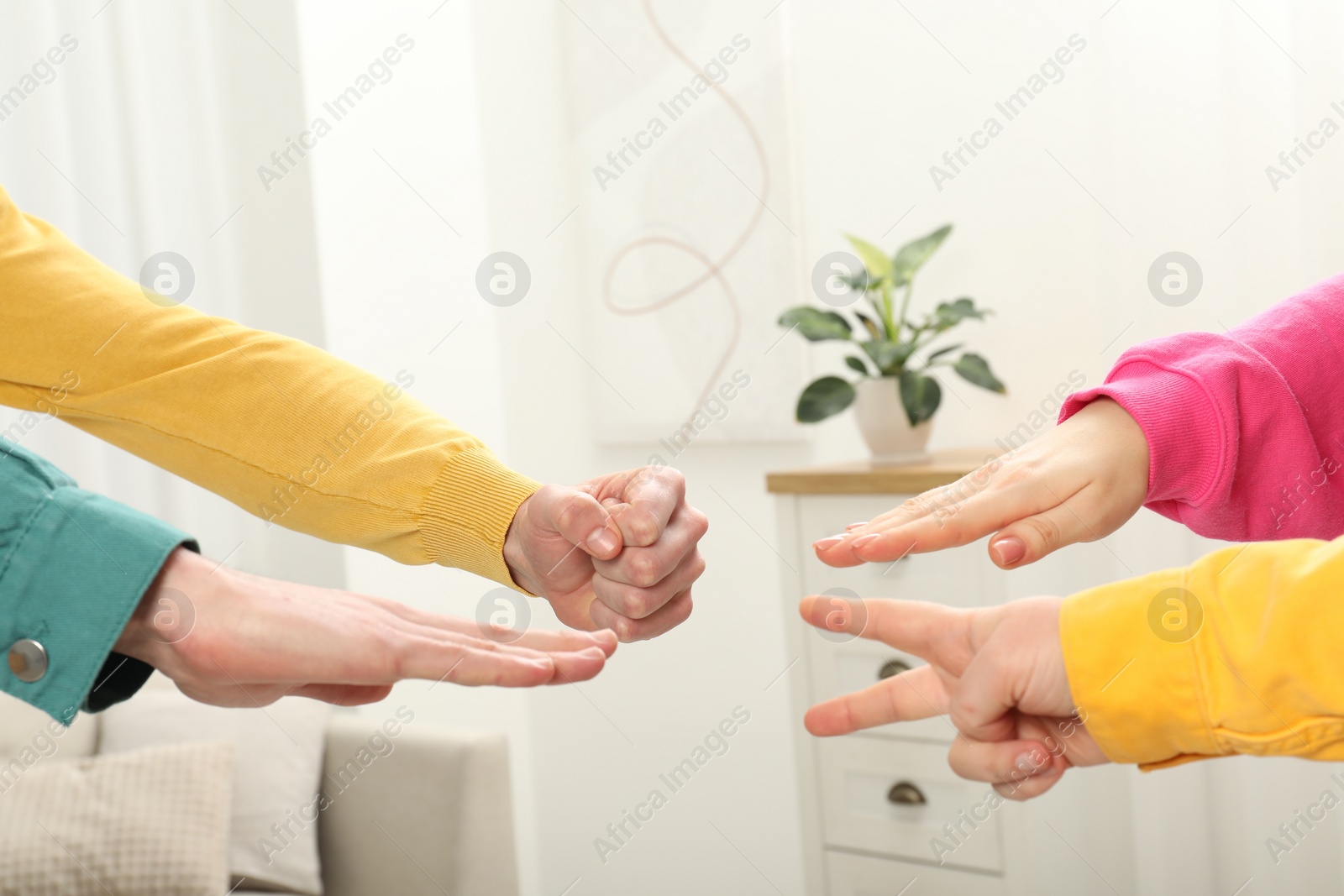 Photo of People playing rock, paper and scissors indoors, closeup