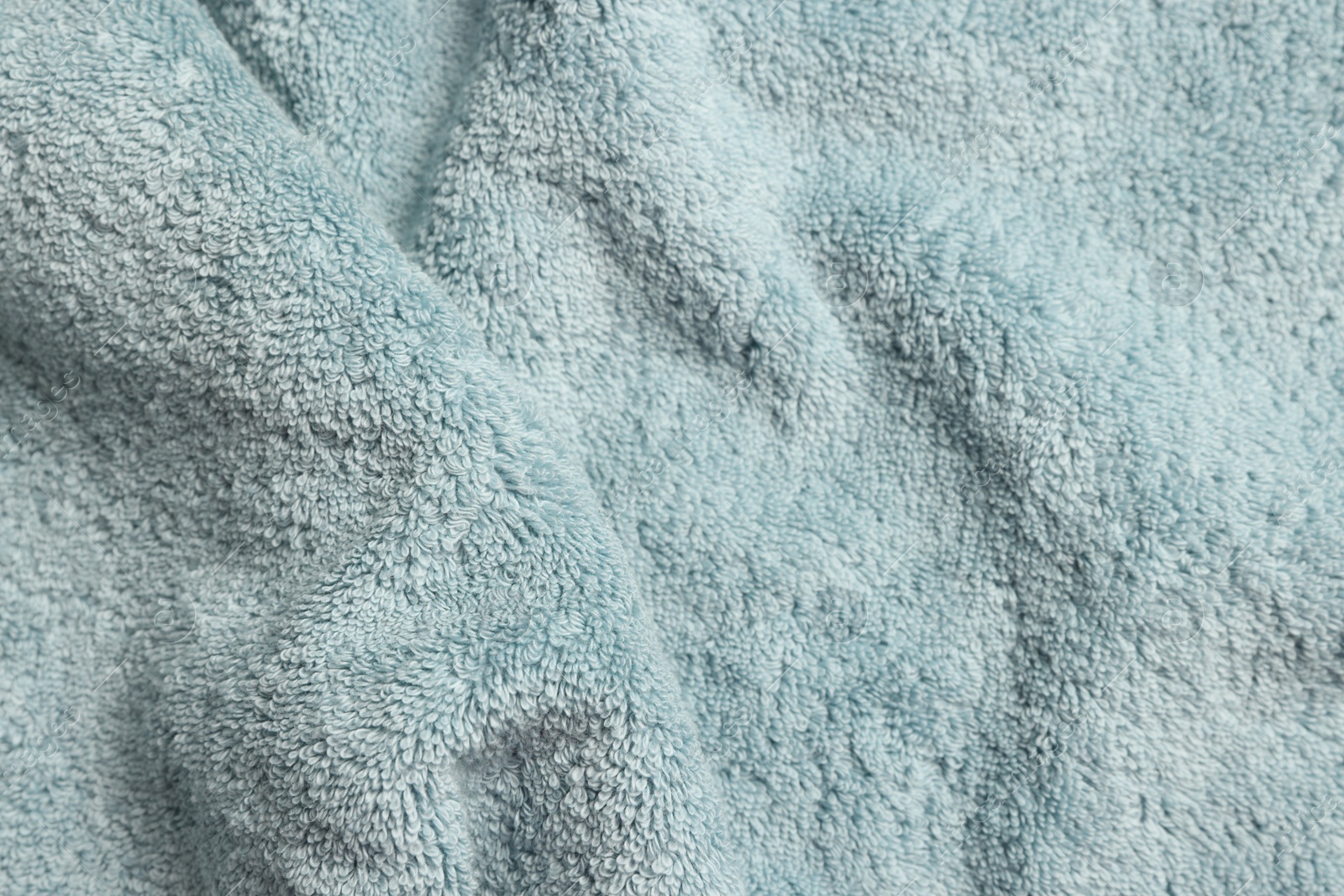 Photo of Soft crumpled light blue towel as background, top view