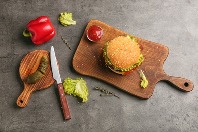 Photo of Flat lay composition with tasty burger on grey background