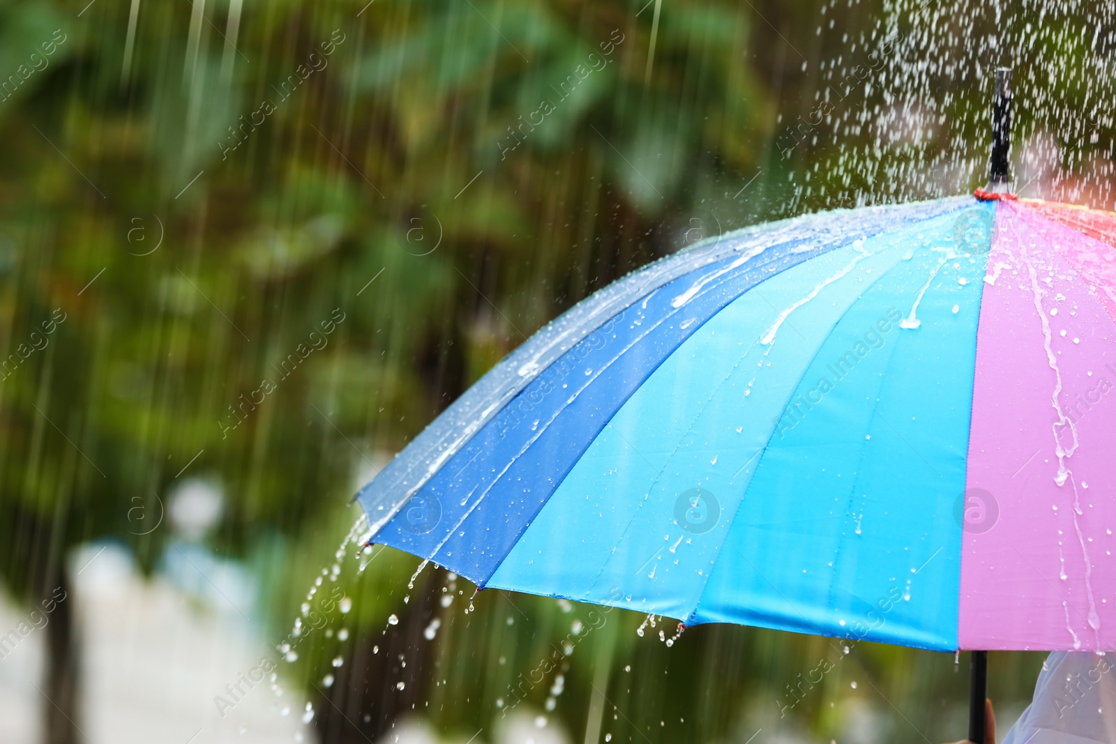 Photo of Person with bright umbrella under rain on street, closeup