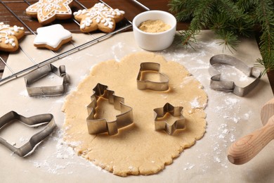 Photo of Making Christmas cookies. Raw dough and different metal cutters on table