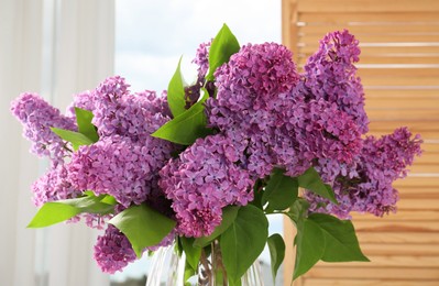 Beautiful blooming lilac flowers in vase indoors