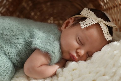 Photo of Adorable newborn baby sleeping on soft plaid, closeup