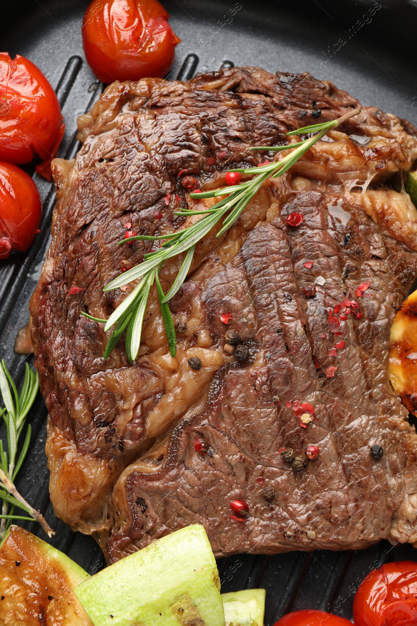 Photo of Delicious grilled beef steak and vegetables in frying pan, top view