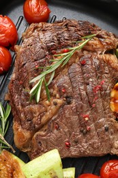 Photo of Delicious grilled beef steak and vegetables in frying pan, top view