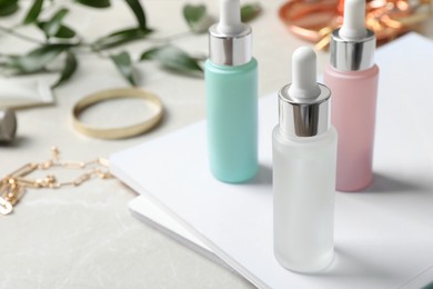 Photo of Bottles of cosmetic products on light grey table, space for text