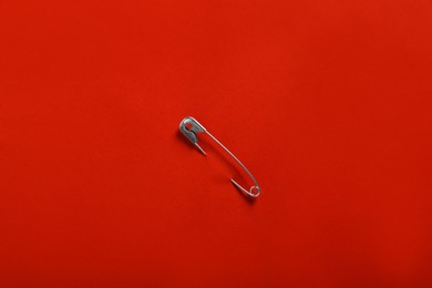 Photo of Safety pin attached on red paper, top view