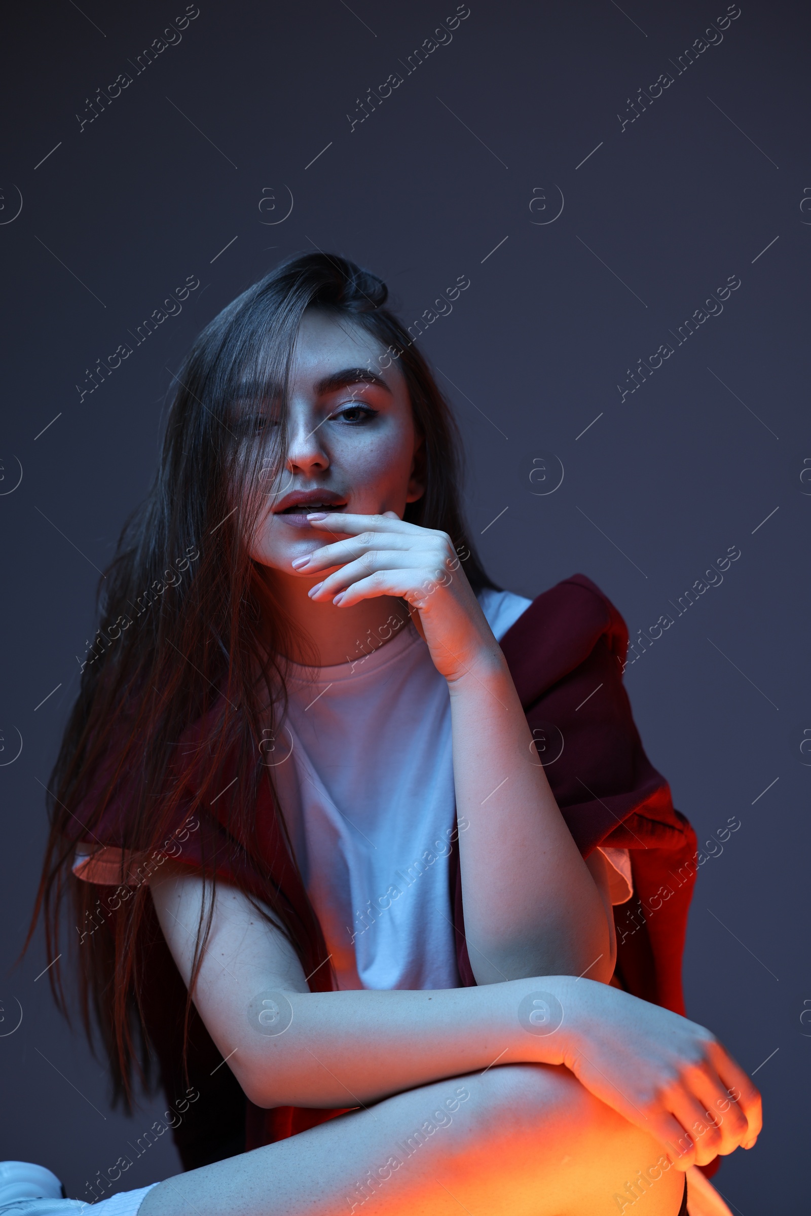 Photo of Portrait of beautiful woman on dark blue background in neon lights