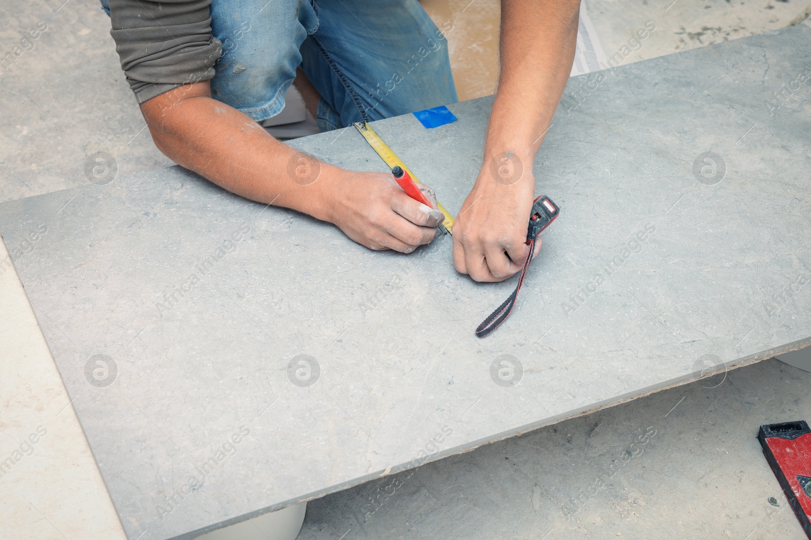 Photo of Worker making socket hole in tile indoors, closeup