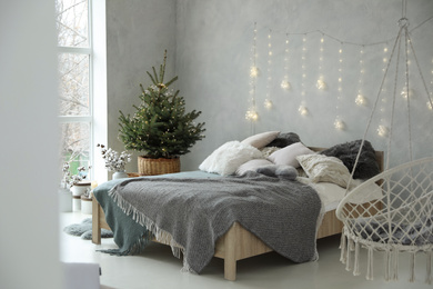 Photo of Elegant bedroom interior with little decorated Christmas tree