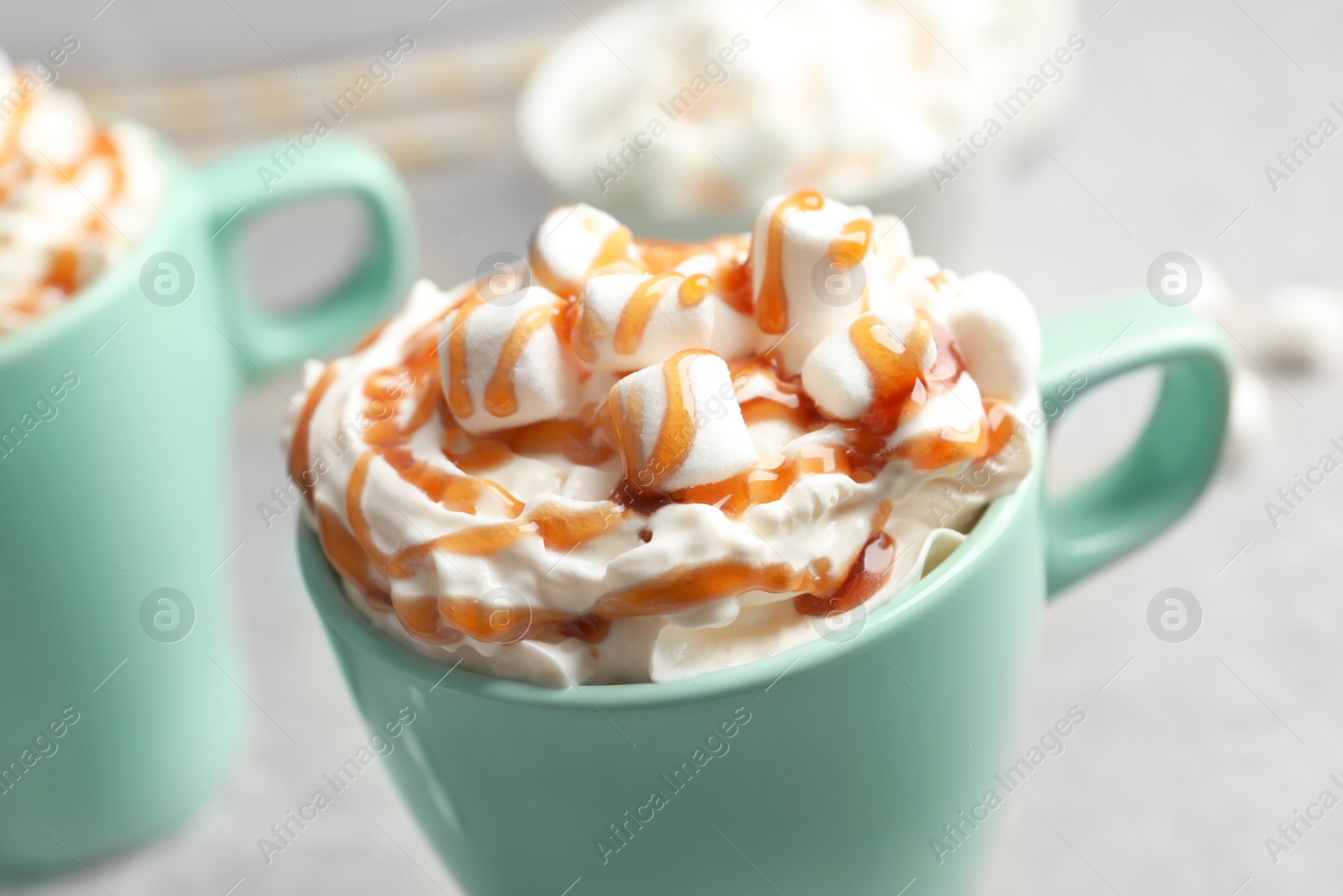 Photo of Cup with delicious caramel frappe on table, closeup