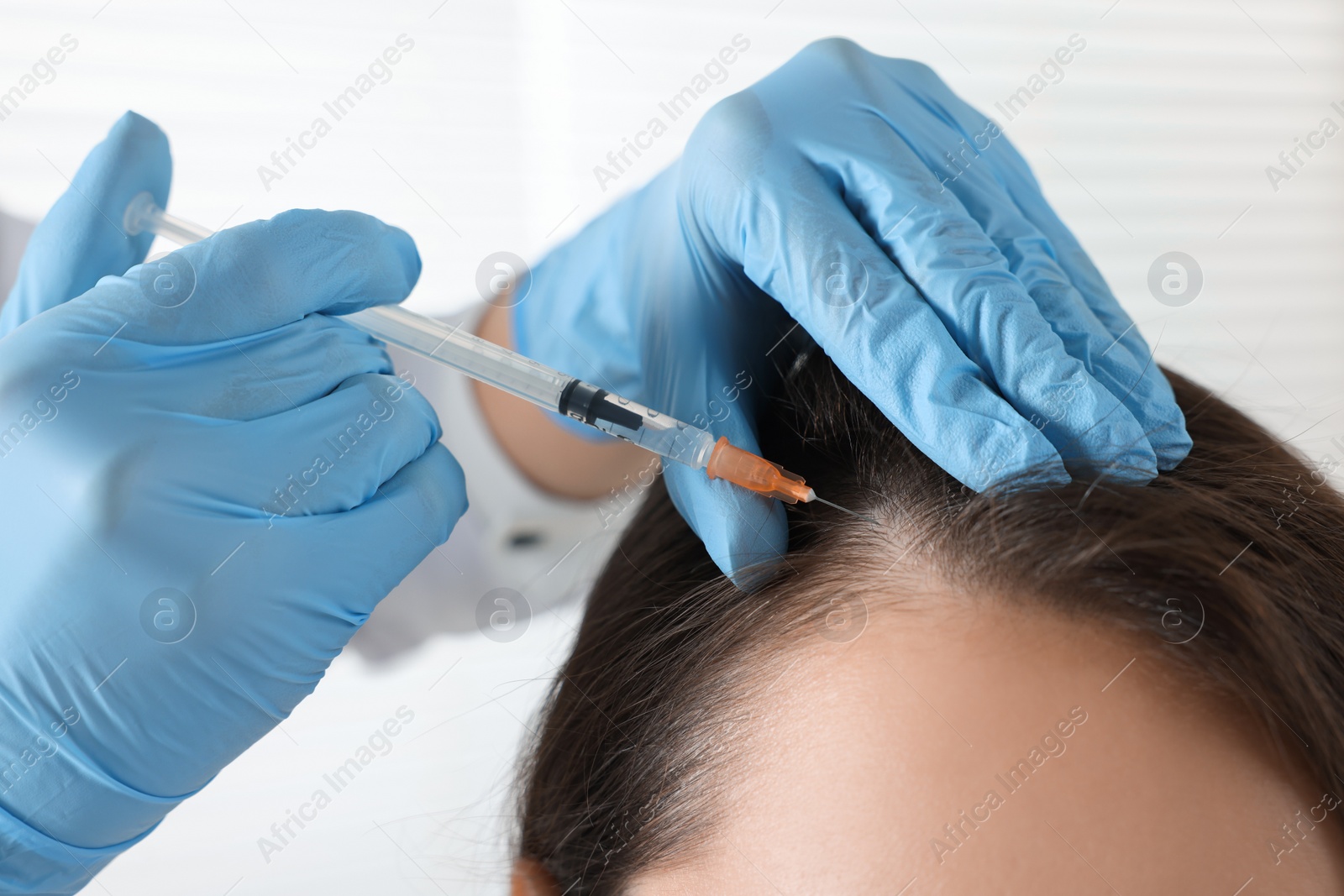 Photo of Trichologist giving injection to patient, closeup view