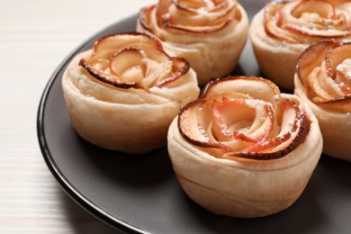 Freshly baked apple roses on white wooden table. Beautiful dessert