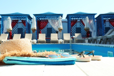 Photo of Beach accessories on wooden deck near swimming pool