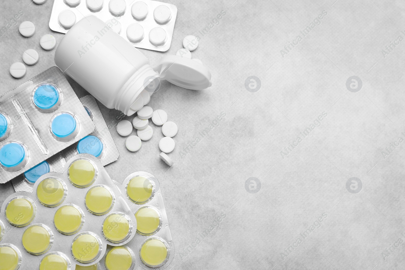 Photo of Many different pills on light grey table, flat lay with space for text. Cough remedies